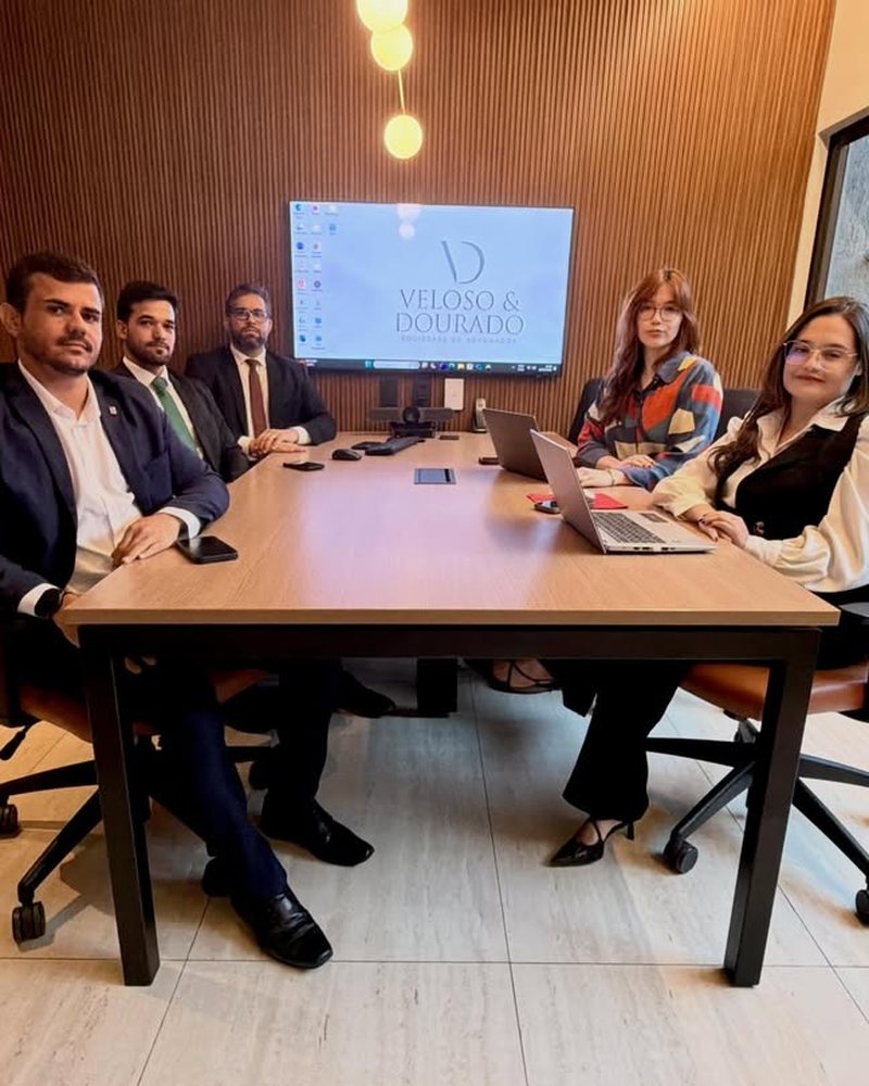 Equipe da Veloso & Dourado reunida na sala de reuniões do escritório